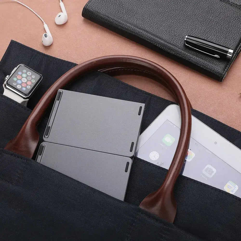Black fabric tote bag with brown leather handles.
