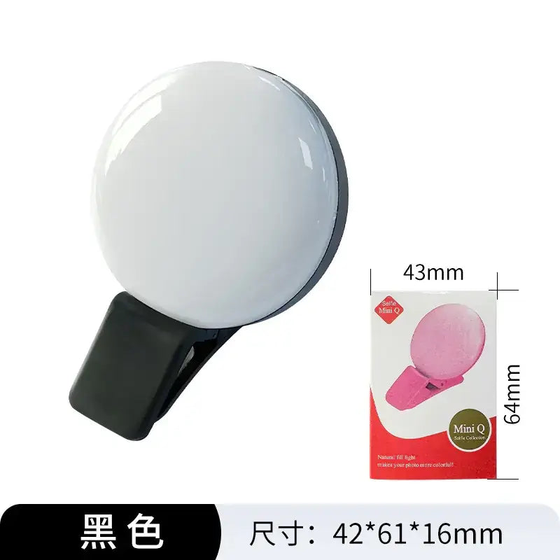 Black circular selfie light with a clip-on design and smooth, glossy white illuminated surface.