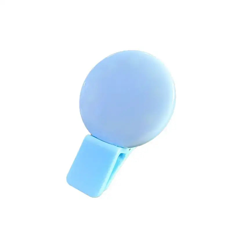 Light blue circular selfie mirror with a clip-on attachment.