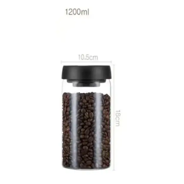 Clear glass coffee bean storage jar with a black lid, holding dark roasted beans.