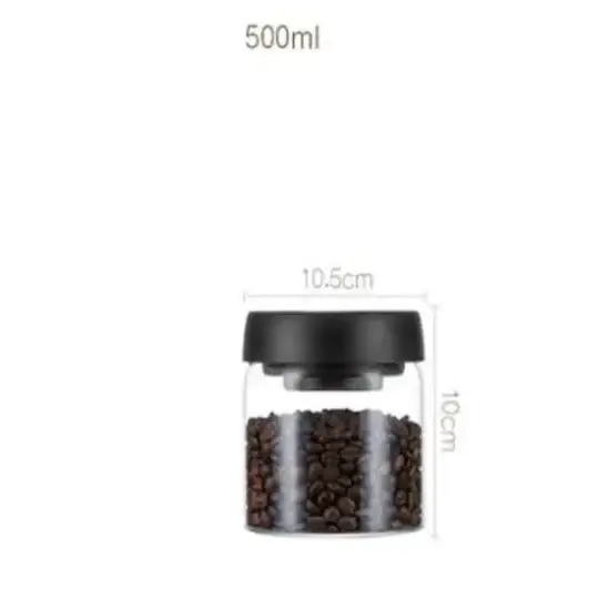 Clear glass jar with a black lid, filled with dark brown coffee beans.