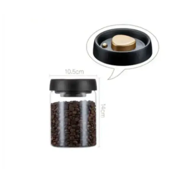 Transparent glass coffee bean storage jar with a black lid featuring a gold-colored push-button mechanism.