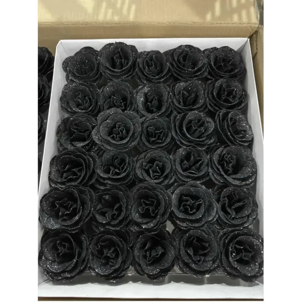 Black glitter roses arranged neatly in a white box.