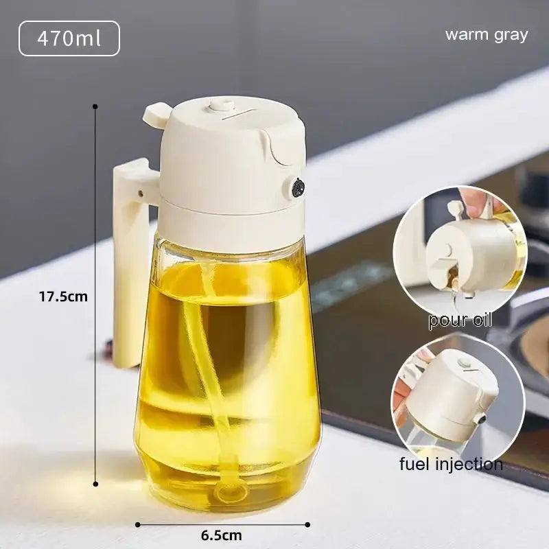 Warm gray plastic oil dispenser with a clear glass body and handle, featuring a pour spout for controlled dispensing.