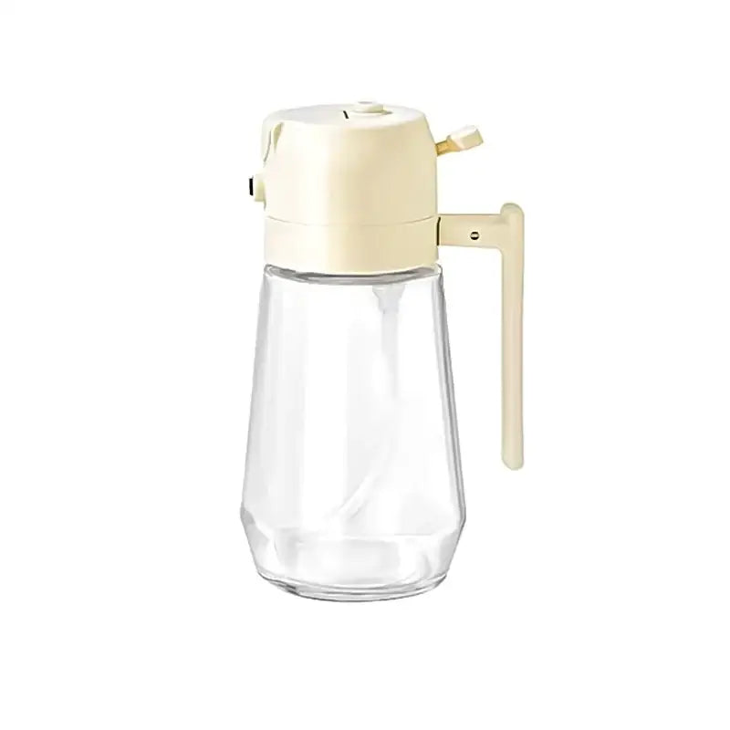 Clear glass syrup dispenser with a cream-colored plastic top and handle.