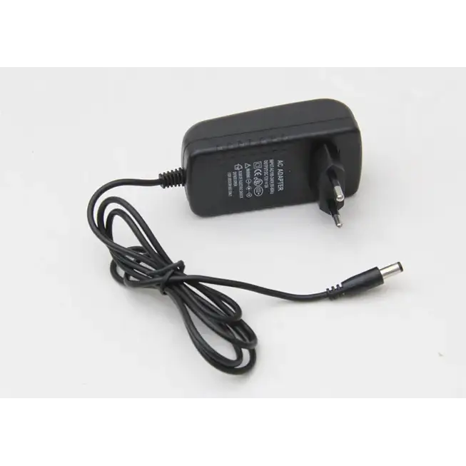 Black plastic ac adapter with a coiled black power cord and european-style plug.
