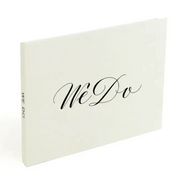 A minimalist off-white wedding guest book with elegant black cursive ’we do’ lettering on the cover.