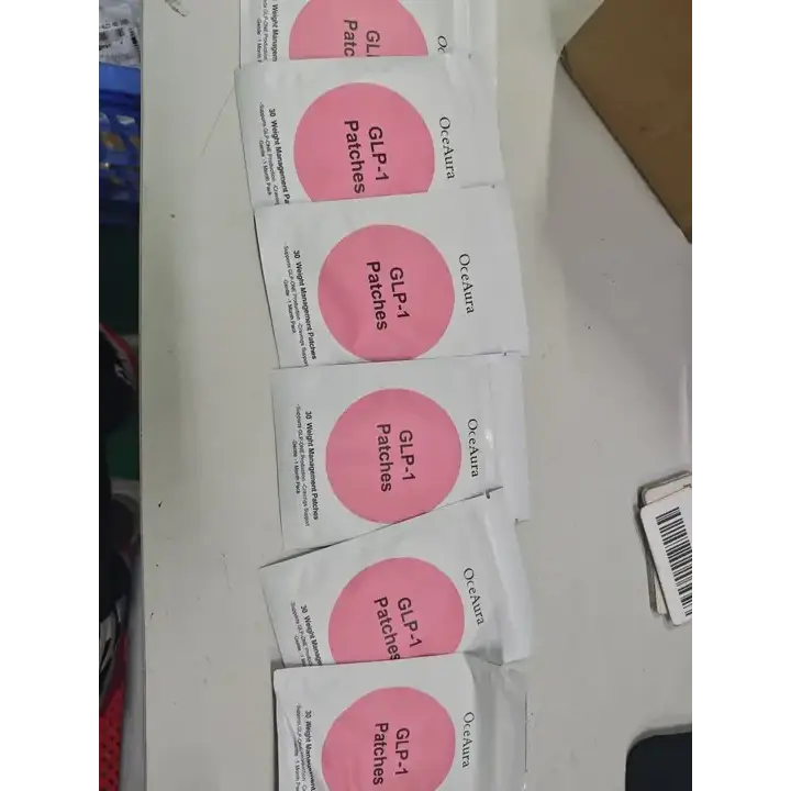 Pink circular patches in white packaging labeled ’oceaura glp-1 patches’.