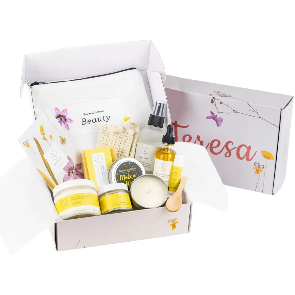 A white and yellow natural beauty gift box filled with assorted skincare, bath, and candle products.