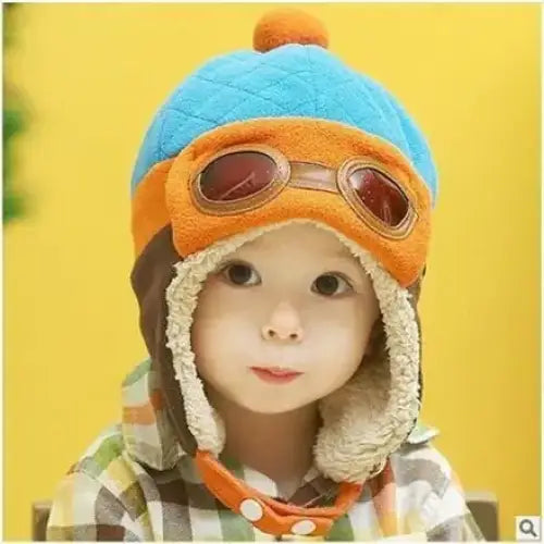 Blue and orange quilted winter hat with faux fur trim and a pom-pom on top