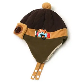 Brown and olive green quilted winter hat with tan trim, a pom-pom on top, and an embroidered airplane design.