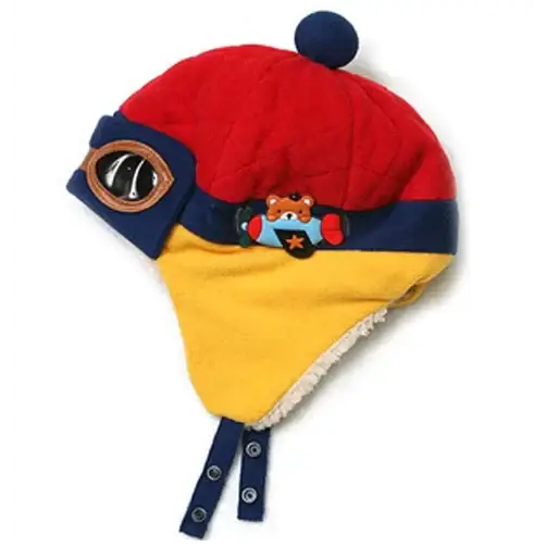 Red and yellow quilted winter hat with a navy blue pom-pom, embroidered airplane patch, and snap closures.