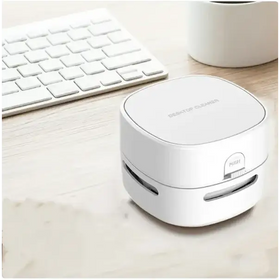 White compact desktop cleaner with a sleek, rounded rectangular design and a ’push’ button on the side.