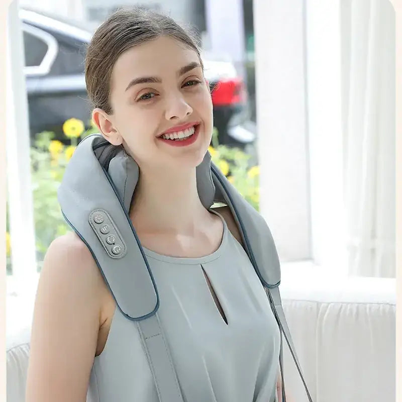 Light gray fabric neck massager with adjustable straps and control buttons.