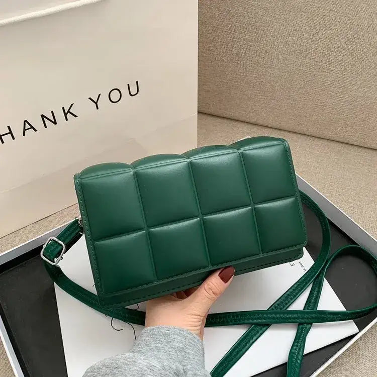 Emerald green quilted leather crossbody bag with a matching strap and silver-toned buckle.