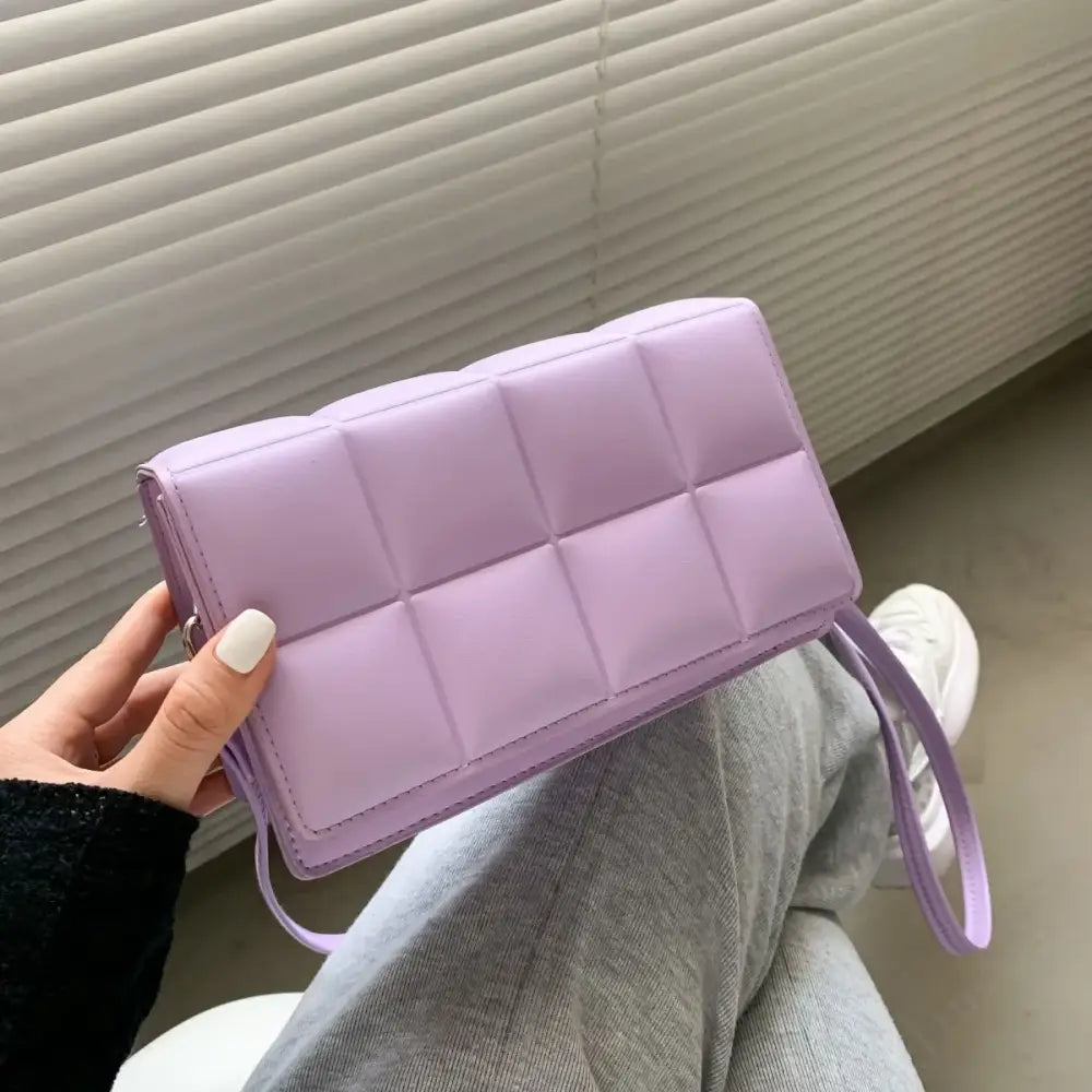A lavender quilted clutch with a matching strap.