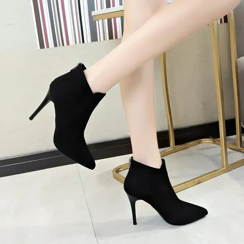 Black suede ankle boots with a pointed toe and slim high heel.