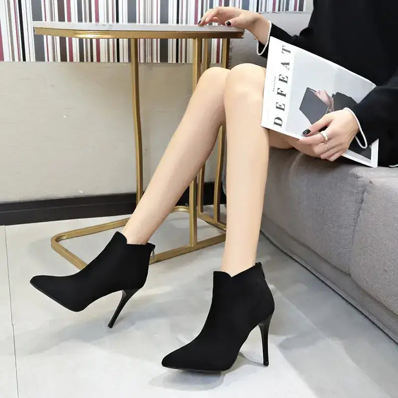 Black suede ankle boots with a pointed toe and slim high heel.