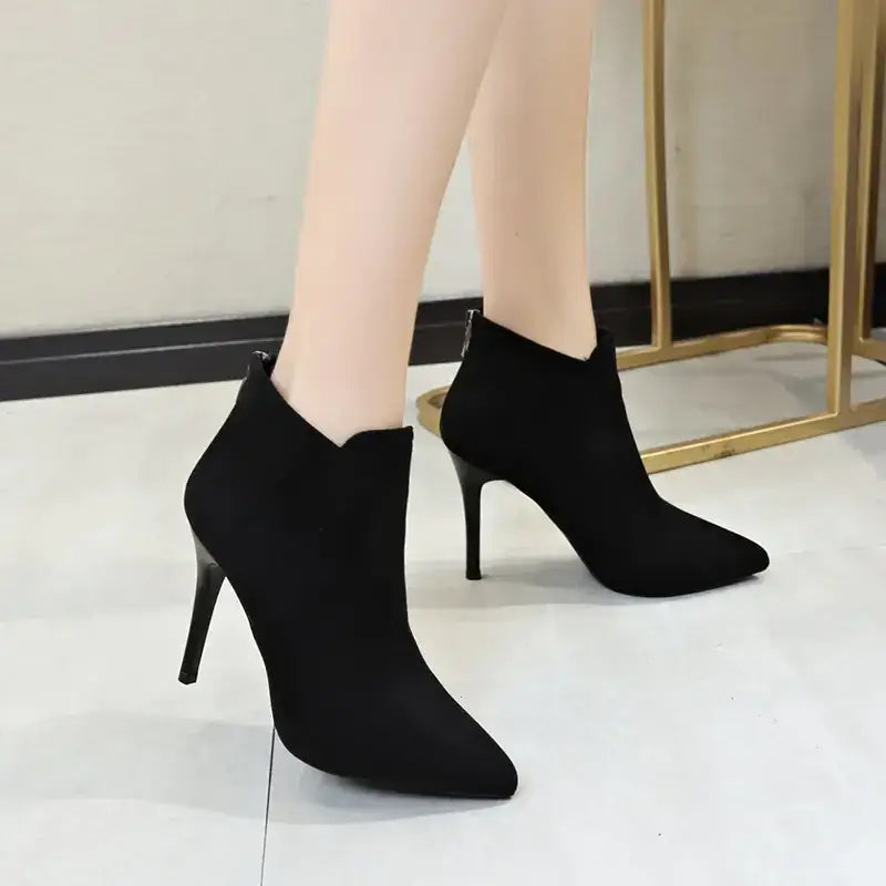 Black suede ankle boots with a pointed toe and slim high heel.
