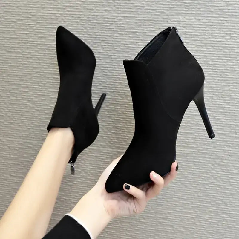 Black suede ankle boots with a pointed toe and slim high heel.