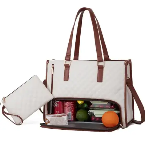 Cream-colored quilted tote bag with brown leather straps and trim, featuring a spacious interior filled with snacks and produce.