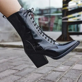 Black patent leather ankle boot with a pointed toe and chunky block heel.