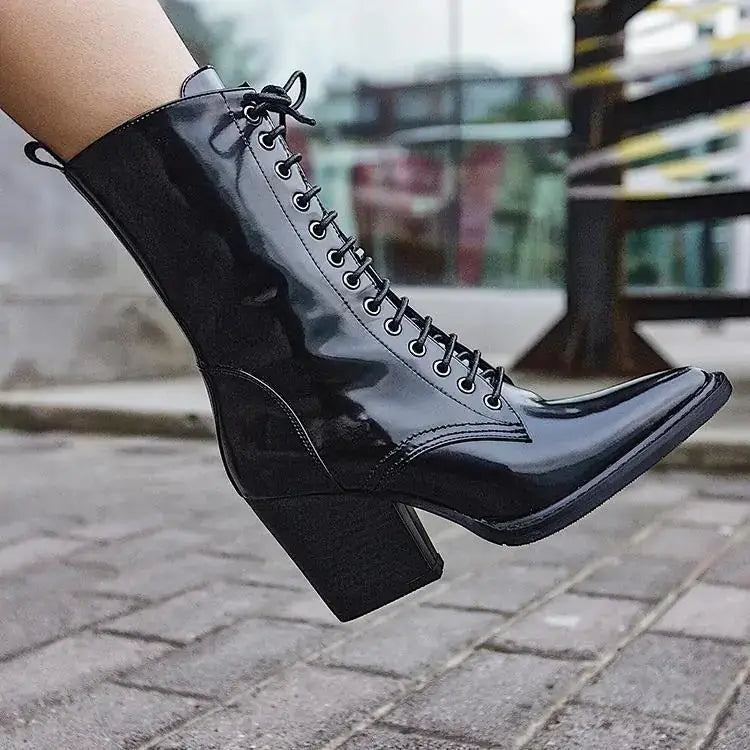 Black patent leather ankle boot with a pointed toe and chunky block heel.