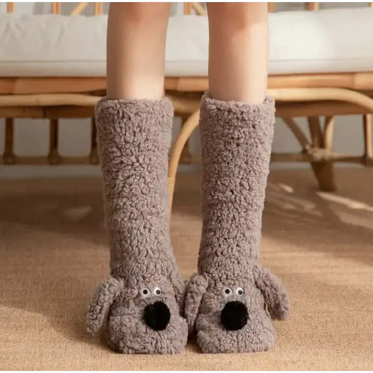 Gray plush dog-shaped slippers with black pom-pom noses and googly eyes.