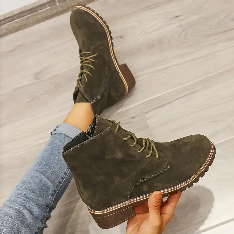 Olive green suede ankle boots with brown rubber soles and matching laces.
