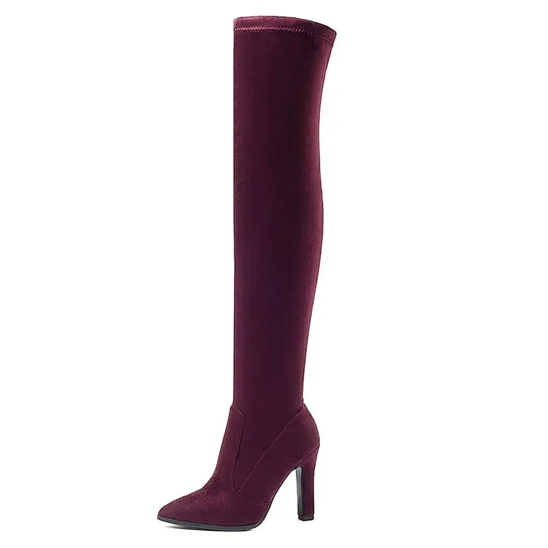 A sleek, burgundy suede over-the-knee boot with a pointed toe and slim heel.