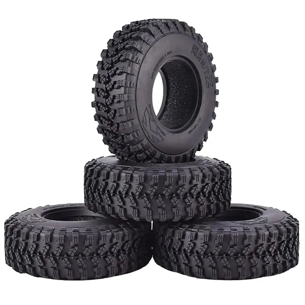 Black rubber off-road tires with aggressive tread patterns, designed for rugged terrain.