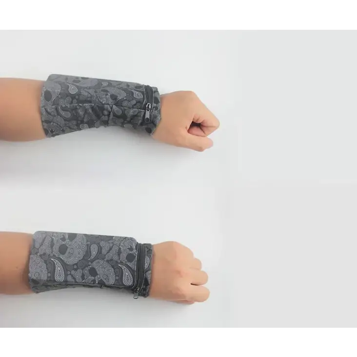 Gray wristband with black and white skull and paisley pattern, featuring a zipper closure.